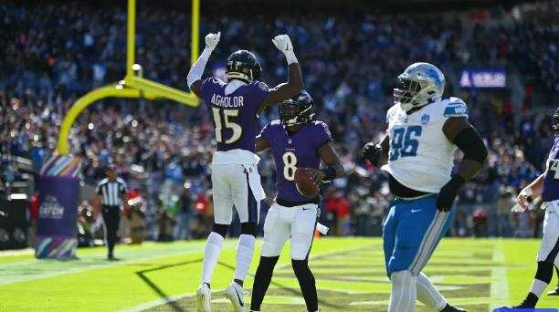 Lamar Jackson (8) celebrates one of his first half touchdowns with Nelson Agholor (15)